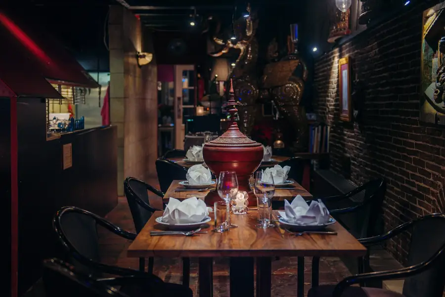 Gedekte tafel met een rood-gouden Thaise schaal op de voet